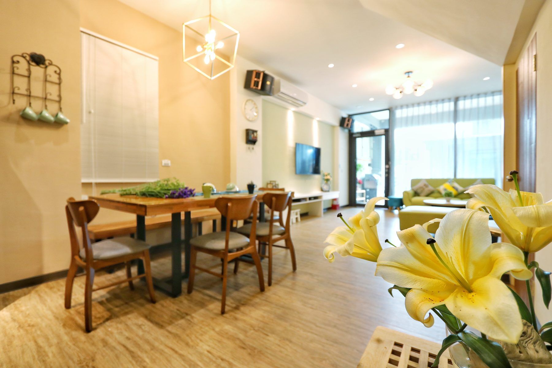 開放式餐廳與客廳，木餐桌搭配綠色沙發區
