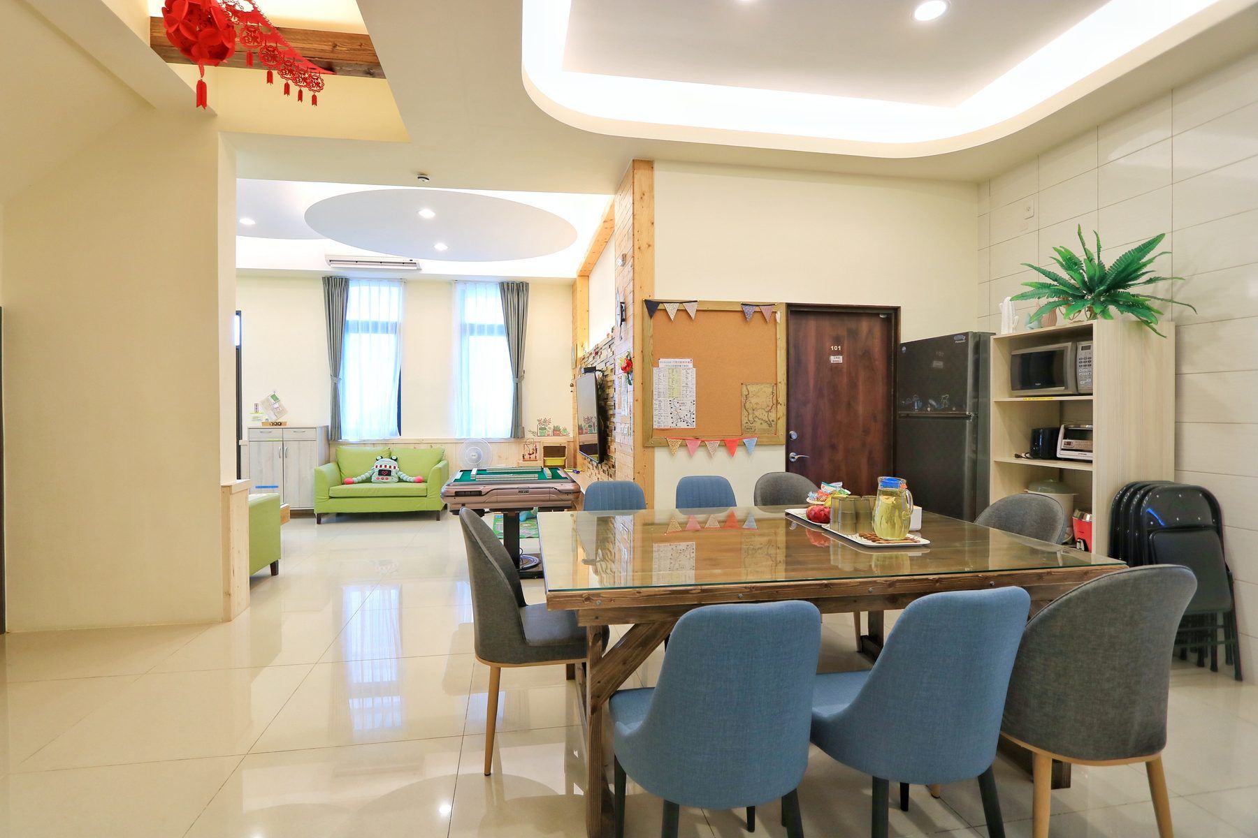餐廳望向客廳，公告板旁是101房門與冰箱